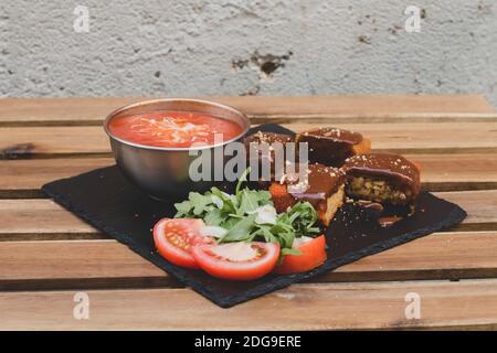 Classique, arancini italien. Boules de riz frits avec viande hachée et quelques légumes à l'intérieur. Savoureux croquant avec sauce aux arachides et soupe aux tomates Banque D'Images