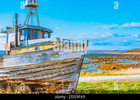 Vieux bateau de pêche abandonné brillant qui est tiré dessus la côte Banque D'Images