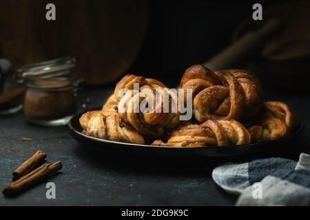 Petits pains à la cannelle traditionnels suédois servis sur une assiette. En-cas très populaire dans toute la Scandinavie. Banque D'Images