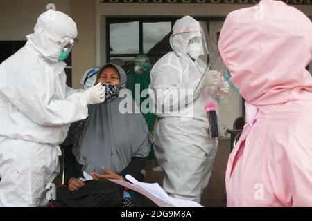 Surabaya, Indonésie. 8 décembre 2020. Les travailleurs médicaux portant des combinaisons de protection prennent un échantillon d'écouvillonnage d'une femme enceinte pour le test COVID-19 à Surabaya, Indonésie, le 8 décembre 2020. Credit: Kurniawan/Xinhua/Alay Live News Banque D'Images