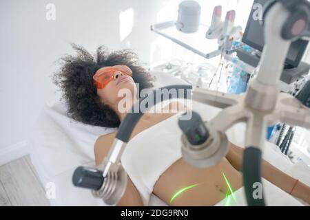 Femme subissant un amincissement au laser au centre de beauté Banque D'Images