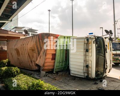 Un camion transportant un conteneur a été renversé sur une route sous un pont au-dessus d'une intersection. Banque D'Images