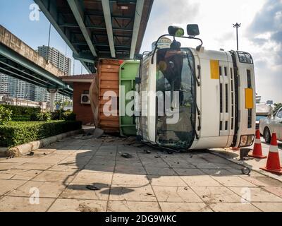 Un camion transportant un conteneur a été renversé sur une route sous un pont au-dessus d'une intersection. Banque D'Images