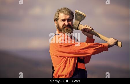 prêt à combattre. réparateur professionnel travaillant avec l'outil de hache. construction. Architecte qualifié réparation et réparation. Carrière d'ingénieur. Homme barbu en uniforme. Homme mature constructeur utiliser hache. Banque D'Images