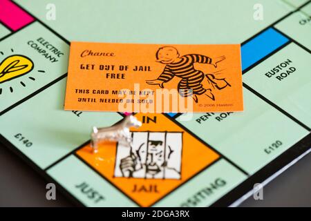 Une chance de sortir de prison carte gratuite sur un Tableau de Monopoly à côté de la pièce de jeu de chien sur le En prison/juste pour visiter la place Banque D'Images