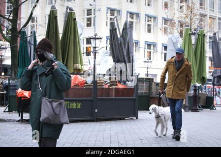 Les gens se promène sur des chaises et des tables empilées d'une terrasse fermée au Leidseplein au centre-ville d'Amsterdam dans le cadre de la pandémie du coronavirus le 8 décembre 2020 à Amsterdam, pays-Bas. Les infections à coronavirus augmentent de nouveau avec 43,103 nouvelles personnes qui ont été testées positives pour le COVID-19 en une semaine selon la dernière enquête de l'institut de santé publique (RIVM). Le Premier ministre néerlandais Mark Rutte tient aujourd'hui une conférence de presse à 19h00 dans la soirée où il annoncera les mesures qui s'appliqueront pendant la période de Noël. (Photoby Paulo Amorim/Sipa USA) Banque D'Images