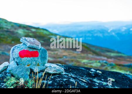 Une roche avec un marquage rouge vif indiquant un chemin à travers les montagnes. Placé par l'association touristique norvégienne DNT. Banque D'Images