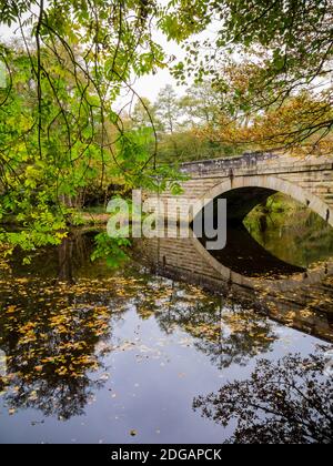 Pont reflété dans les eaux calmes de la rivière Derwent Près de Froggatt dans le parc national de Peak District Derbyshire England ROYAUME-UNI Banque D'Images