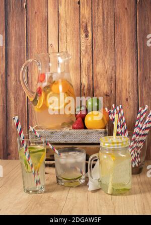 Grand pichet en verre avec eau aromatisée aux agrumes et limonade maison. Verre ou pot avec boisson, couvercle et paille. Fraîcheur, santé et sans alcool Banque D'Images