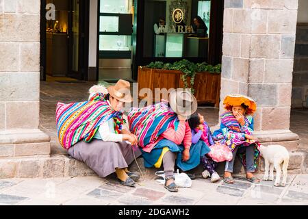 Des péruviens non identifiés avec leur animal assis devant une boutique à cusco pour prendre un repos Banque D'Images