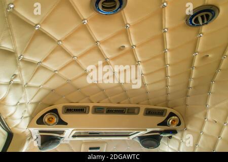 Intérieur de luxe en limousine avec du cuir marron au plafond. L'intérieur haut de gamme d'une fourgonnette grand angle vintage présente une décoration classique. Banque D'Images