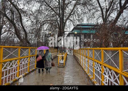 Srinagar, Inde. 08 décembre 2020. Les femmes marchent avec un parapluie pendant une pluie.des endroits plus élevés de la vallée du Cachemire ont reçu des chutes de neige pour le deuxième jour, tandis que les plaines ont été heurtées par des pluies, a déclaré un responsable. Crédit : SOPA Images Limited/Alamy Live News Banque D'Images