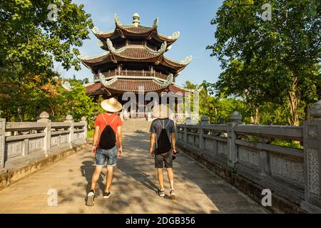 Deux touristes marchant vers une pagode dans le complexe de temples bouddhistes de Bai Dinh, le plus grand au Vietnam, situé dans la province de Ninh Binh. Banque D'Images