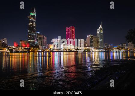 Vue nocturne pittoresque et colorée de la ville de Ho Chi Minh sur le fleuve Saigon. Des gratte-ciels et des bâtiments modernes sont situés dans le quartier 1. Banque D'Images