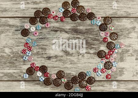 Des boutons de formes et de couleurs différentes sont disposés sur un arrière-plan en bois clair Banque D'Images