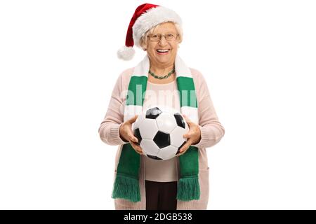 Femme âgée fan de football avec un foulard et un football porter un chapeau de père noël isolé sur fond blanc Banque D'Images