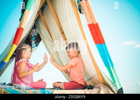 Les enfants adorables jouent dans la tente. Enfants jouant avec une tente de tipi. Banque D'Images