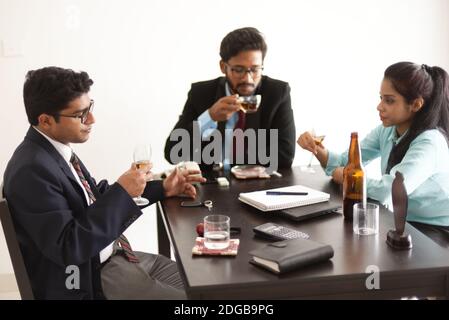 Les fêtes d'entreprise se passent avec de la fumée, des boissons non alcoolisées, du thé et du vin. Style de vie d'entreprise indien Banque D'Images