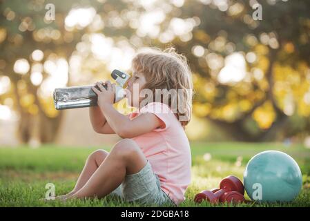 Sport amusant pour enfants. Concept de l'eau potable. Enfant garçon avec une bouteille d'eau. Enfant avec eau potable dans le parc. Développement des enfants et sain fort Banque D'Images