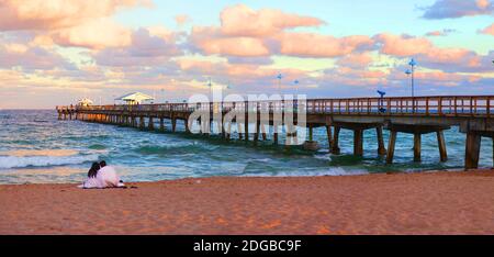Couple assis sur la plage au coucher du soleil, fort Lauderdale, Floride, États-Unis Banque D'Images