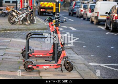 Petit groupe de scooters électriques à louer - garés sur la chaussée à côté de la route à Bath, Somerset, Royaume-Uni le 8 décembre 2020 Banque D'Images