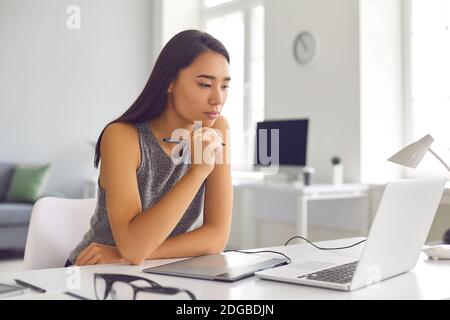 Artiste numérique, web designer ou retouche photo pensive travaillant avec une tablette ou un ordinateur portable Banque D'Images