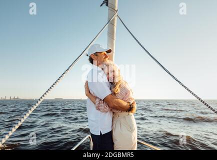 Couple romantique âgé s'embrassant l'un l'autre sur l'arc de yacht Banque D'Images