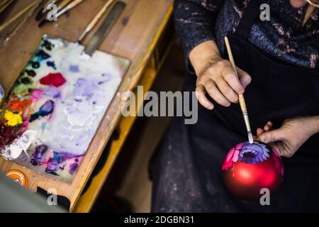 Moscou, Russie. 8 décembre 2020. Un artiste décore un ornement à l'usine de peinture décorative de Zhotovo, dans la région de Moscou, en Russie, le 8 décembre 2020. Zhotovo est un centre d'art populaire russe célèbre pour ses plateaux peints décorés de petits pains de fleurs. Crédit: Maxim Chernavsky/Xinhua/Alay Live News Banque D'Images