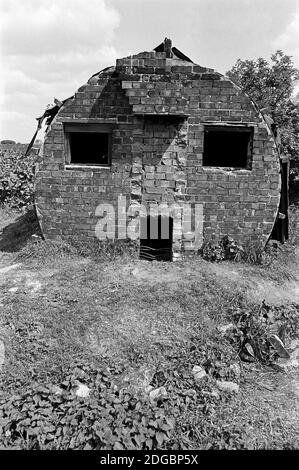 Royaume-Uni, Londres, Docklands, Isle of Dogs, début 1974. Les huttes du ministère de la Guerre ancienne (WW2) ont été utilisées par les détenteurs de l'allotissement sur la goulotte de boue, une zone de terres en friche. Maintenant connu sous le nom de Mudchute Park and Farm dans Cubitt Town. C'est une réserve naturelle locale et un site d'importance métropolitaine pour la conservation de la nature. Banque D'Images