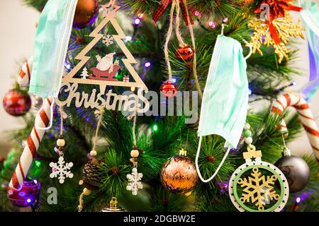 Décorations de Noël et un masque de visage accroché à un Noël arbre Banque D'Images