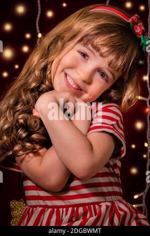 Portrait d'une fille souriante devant les lumières de Noël Banque D'Images