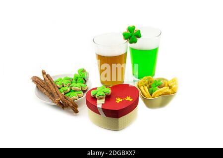 Deux verres de bière avec lager vert en mousse avec encas bâtons de viande boîte cadeau. Saint-Patrick Banque D'Images