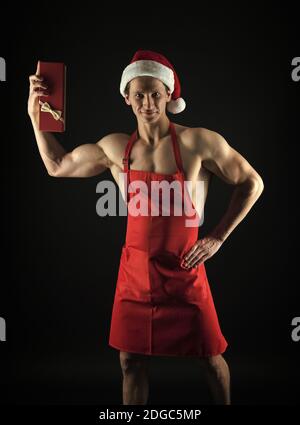 Présent remise en forme pour sportifs fanatique. Homme heureux tenir présent fort. Cook athlétique sourire avec cadeau de Noël. Boxing day. Présent du Père Noël. Don de la santé. Démarrer une nouvelle année de congé plus fort que jamais. Banque D'Images