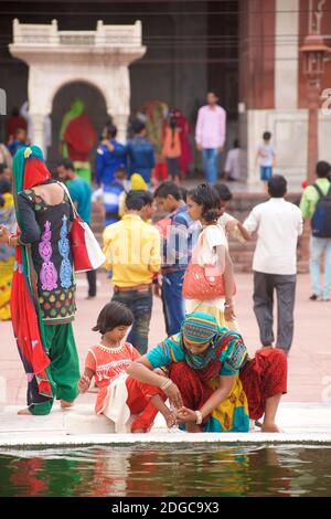 Des personnes se sont rassemblées près de la fontaine dans la cour centrale de la Jama Masjid, une mosquée de style moghol du XVIIe siècle, dans la vieille ville de Delhi, en Inde Banque D'Images