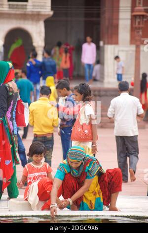 Des personnes se sont rassemblées près de la fontaine dans la cour centrale de la Jama Masjid, une mosquée de style moghol du XVIIe siècle, dans la vieille ville de Delhi, en Inde Banque D'Images