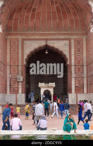 Des personnes se sont rassemblées près de la fontaine dans la cour centrale de la Jama Masjid, une mosquée de style moghol du XVIIe siècle, dans la vieille ville de Delhi, en Inde Banque D'Images