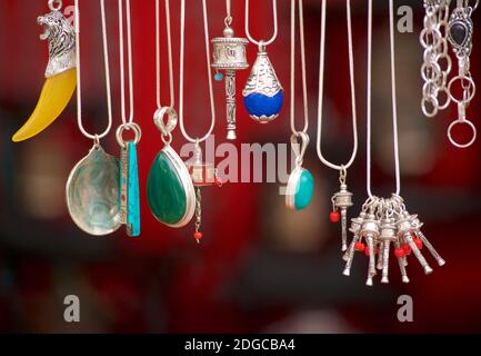 Souvenirs indiens de bijoux du Ladakh. Cravates et breloques argentées avec pierres de couleur. Inde Banque D'Images