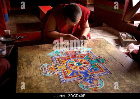 Monk au monastère de Lamayuru, Ladakh créant un mandala de sable coloré. Lamayouro, Ladakh, Jammu-et-Cachemire, Inde. Un mandala de sable est ritualistiquement démantelé une fois qu'il a été achevé et ses cérémonies d'accompagnement et de visualisation sont terminées pour symboliser la croyance doctrinale bouddhiste dans la nature transitoire de la vie matérielle. Banque D'Images