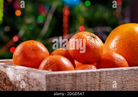 Clémentines ou tangerines dans la boîte sur les lumières de noël. Banque D'Images