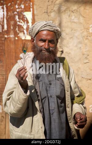 Un musulman avec une barbe au gingembre tenant une plume de paackock, Kargil, Jammu et Cachemire, Inde Banque D'Images