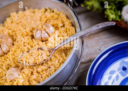 Pilaf ouzbek, riz à l'ail dans une marmite en fer et une assiette. Banque D'Images