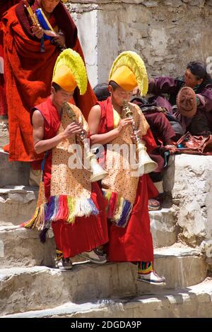 Moines à chapeau jaune portant des chapeaux tsoksha jaunes et des trompettes tibétaines soufflantes, festival Karsha Gustar, monastère de Karsha, près de la vallée de Padum Zanskar, Ladakh, Jammu-et-Cachemire, nord de l'Inde Banque D'Images