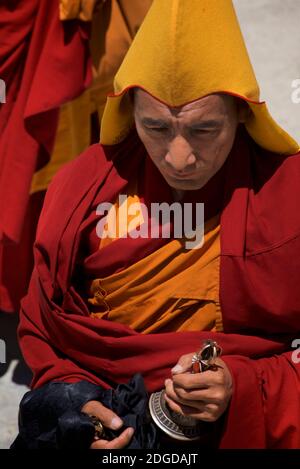 Chapeau jaune bouddhiste Lama dans la tenue monastique et la cloche, Karsha monastère, près de la vallée de Padum Zanskar, Ladakh, Jammu et Cachemire, nord de l'Inde Banque D'Images