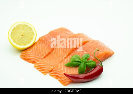 Morceaux de saumon frais, piment rouge, citron isolé sur blanc Banque D'Images