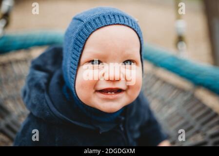 Adorable bébé avec deux dents à l'avant souriant dehors dans le froid hiver Banque D'Images