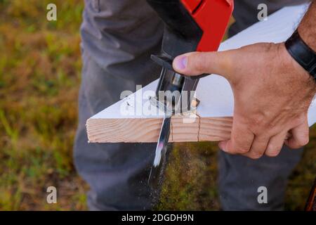 Scie sauteuse professionnelle, lame de scie en bois coupée près de la main du menuiserie avec de la sciure. Banque D'Images