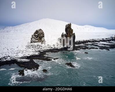 Vue panoramique sur les formations rocheuses rugueuses sur la rive près de la mer En terrain enneigé en Islande Banque D'Images