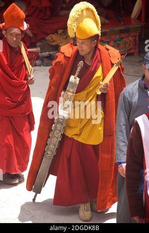 Chapeau jaune lama dans des robes monastiques cérémonielles avec le personnel en métal traditionnel. Festival Zanskar / Karsha Gustar, célébré au monastère de Karsha, près de la vallée de Padum Zanskar, Ladakh, Jammu et Cachemire, nord de l'Inde Banque D'Images