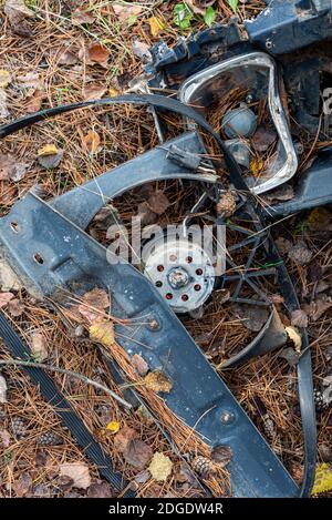 Vieux rouillé pièces de voiture douilles de lampe et d'embrayage à l'automne sol forestier entouré de feuilles de bâtons secs Banque D'Images