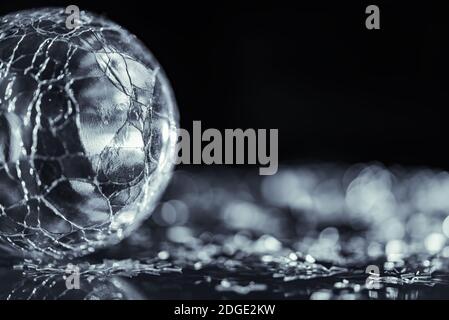 Photo macro de l'étoile argentée brillante et de la sphère de verre fissurée Banque D'Images